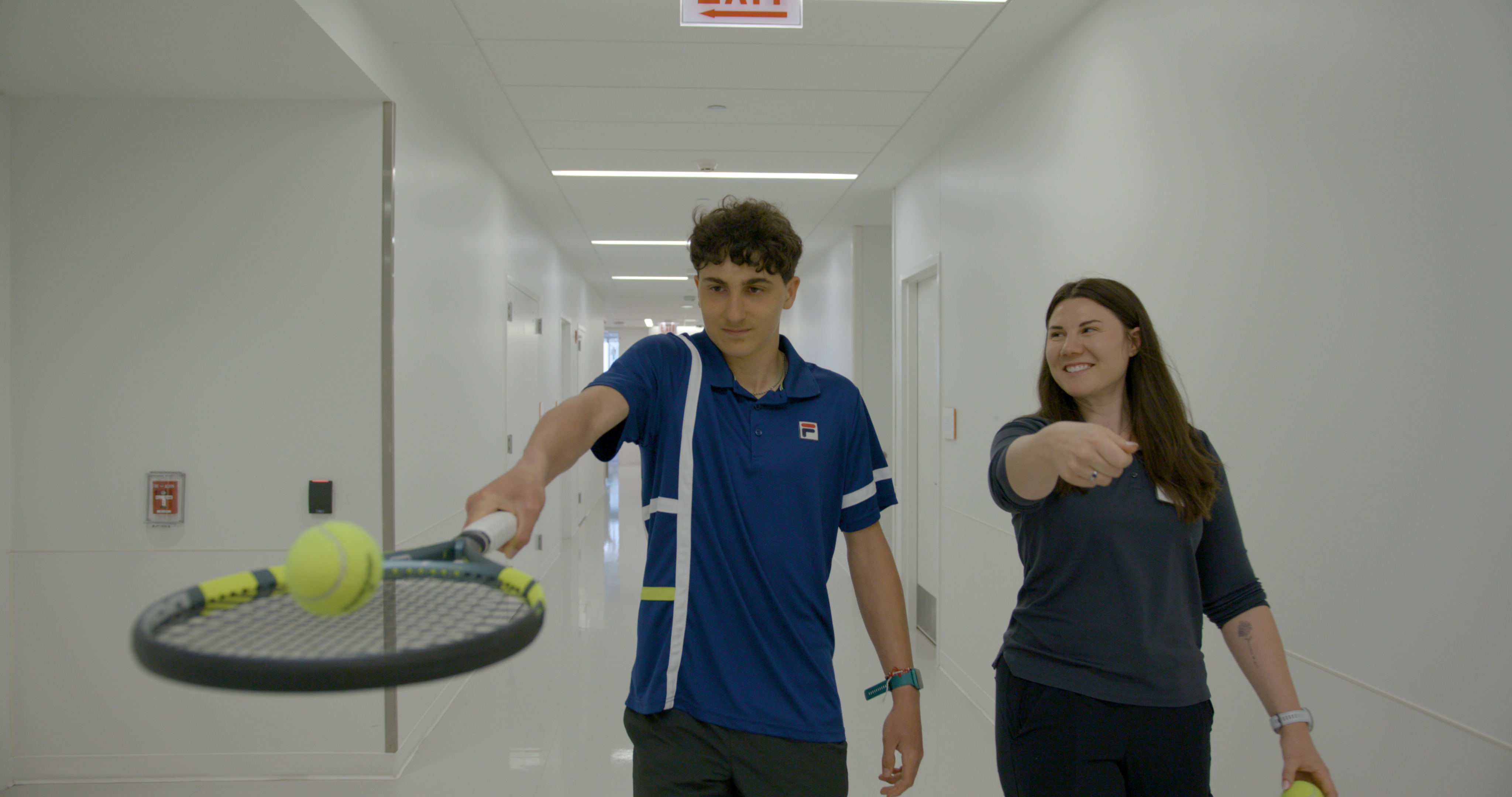 Kellan walking with tennis racquet