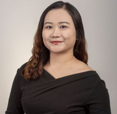 color photo of Melody Yang, a young Asian woman with curly black hair and a black v neck top