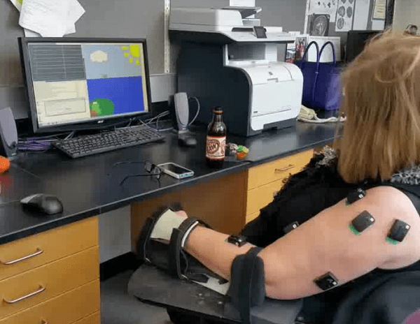 woman particpating in video game with muscle sensors on arm