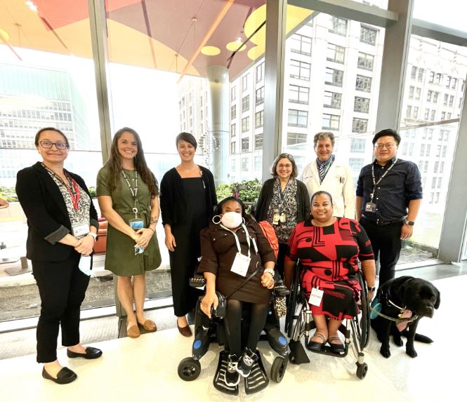 group photo of 8 people, two in wheelchairs