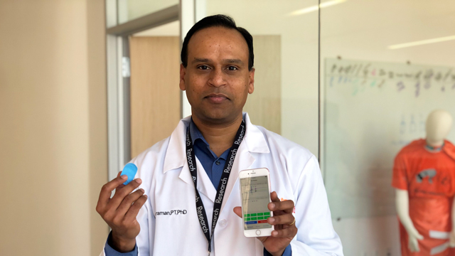 Shirley Ryan AbilityLab Scientist Arun Jayaraman, PT, PhD holding COVID-19 wearable device