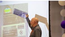 SRAlab senior therapist Ed Hitchcock, OT/L holding an adaptive keyboard.