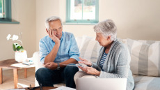 Older couple in their 70s looking at each other worried