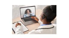 A picture of two woman who are black, one woman in wearing a white coat and one woman is on a computer screen and a carrying out a virtual conversation.