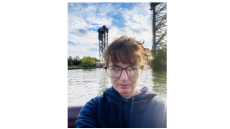 Woman with brown hair and glasses on a boat on a river