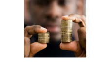 black man holding two stacks of coins in his hands