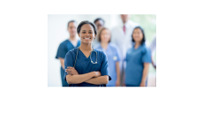 African American nurse with arms crossed and smiling with nurse colleagues in the bacground