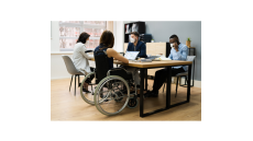 people around a table, one with a wheelchair