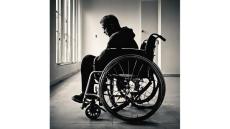 black and white photo of person in a wheelchair looking depressed