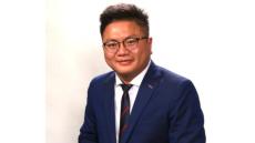 color photo of Chinese man in suit and glasses smiling