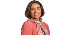 color photo of Linda Ehrlich-Jones, a middle aged white woman with shirt brown hair and a pink jacket