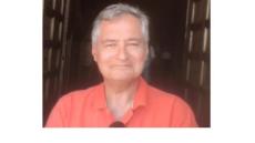 A photo of Roman - a middle aged white man with short grey hair and a pink t shirt