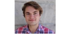 photo of Ross Kaine, a young white man with brown short hair wearing a blue and pink plaid shirt