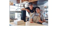 color photo of a man and a younger boy in a coffee shop