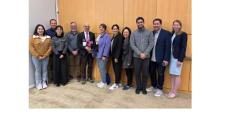 Allen Heinemann holding flowers along with mentees and colleagues at the Mentor of the Year ceremony