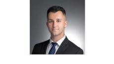 photo of Robert Cotter, a young white man with brown hair wearing a suit and tie