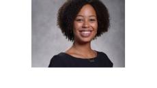 color photo of diminique kinnet hopkins, a young Black woman with short curly black hair and a black top