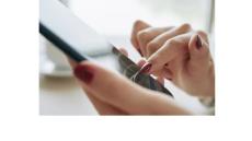 a photo of a pair of white woman's hands with red nail polish holding a cell phone