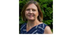 color photo of Jane Duff, a middle aged white woman with short brown hair wearing a flowered blue tank top