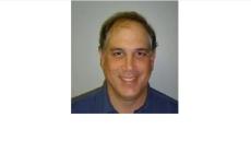 Color photo of Eric Lipp, a middle aged white man wearing a grey shirt