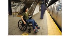 Photo of a woman in a wheelchair at a subway platform