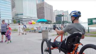 Brad the Bullet Baker riding a hand cycle on a beach in chicago