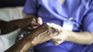 Nurse holds hands of patient