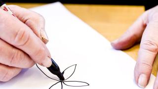 An MS patient works on their fine motor skills by drawing a flower