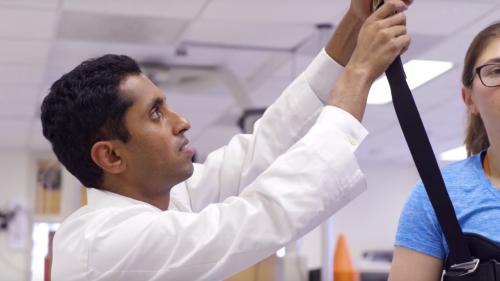 Prakash Jayabalan helps a concussion patient on a gait track