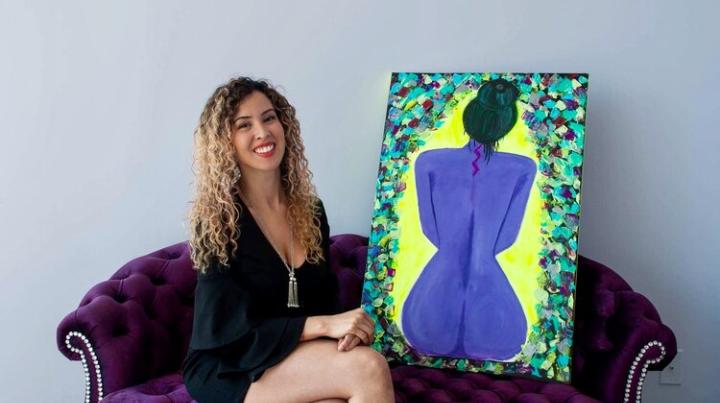 Genevieve in her studio with one of her paintings
