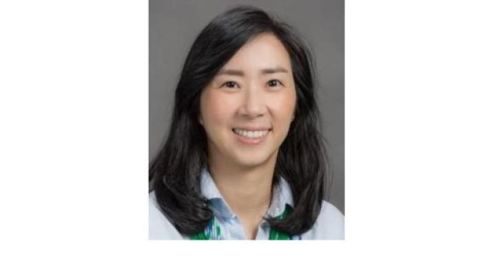 Color photo of Danbi Lee, a young Asian woman with shoulder length black hair wearing a light blue button down shirt