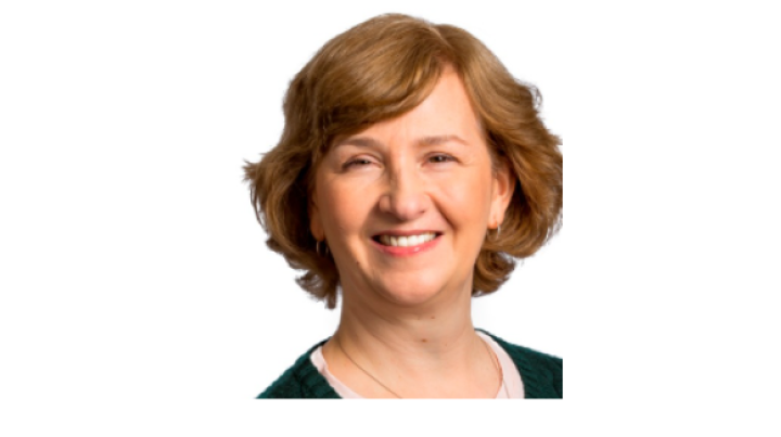 color photo of Anne Deutsch, a middle aged white woman with short blonde hair wearing a black top.