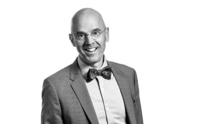 photo of Allen Heinemann, an white mad with glasses wearing a grey suit and bowtie