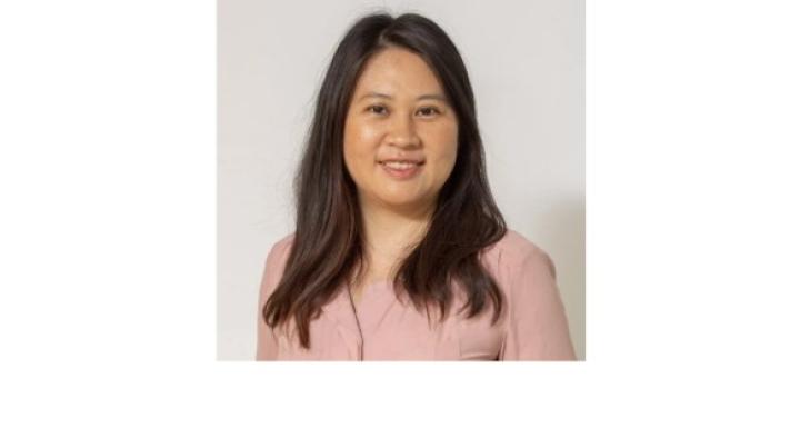 Color photo of Manrui Zhang, a young Chinese American woman with shoulder lengths black hair wearing a pink blouse