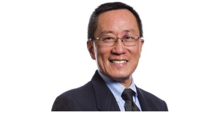 Color photo of Dr. David Chen, a middle aged Asian man wearing glasses and a dark suit with a light blue shirt
