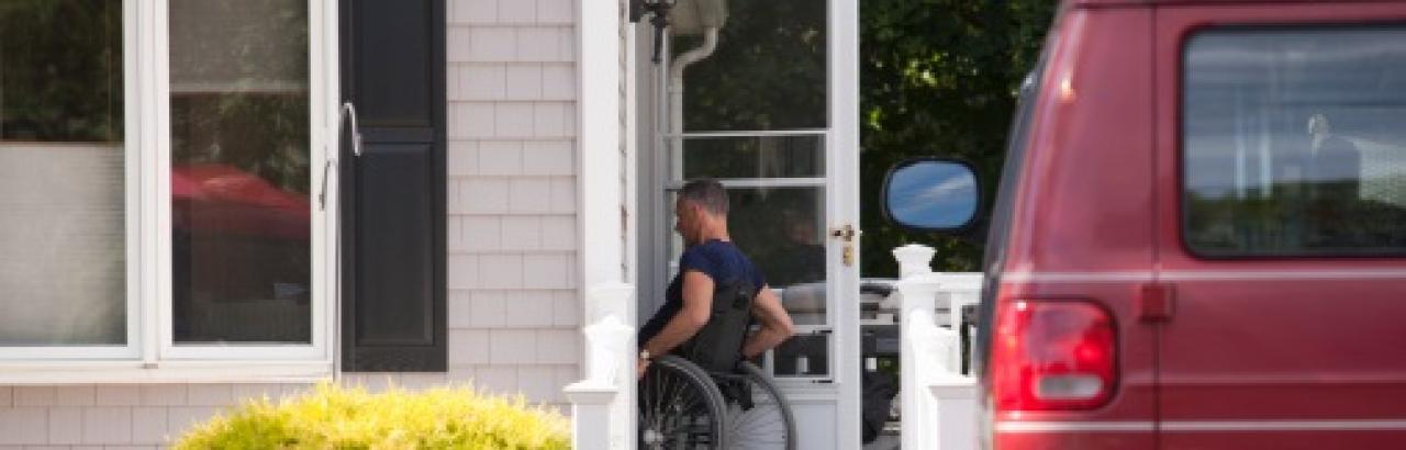 man in wheelchair going into house
