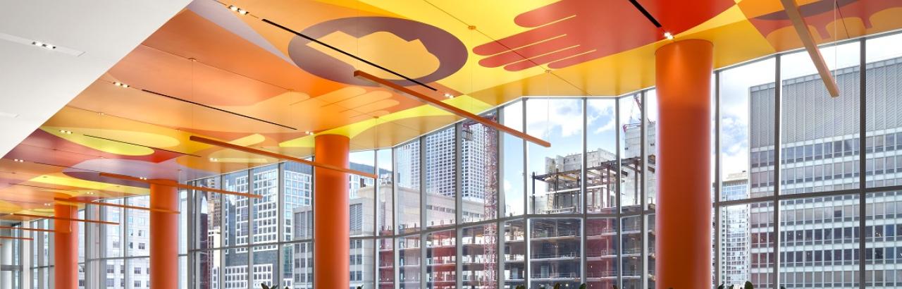 the Sky Lobby of Shirley Ryan AbilityLab. Orange ceiling, white floors with planters and large windows