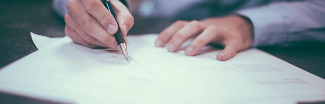 man writing on paper