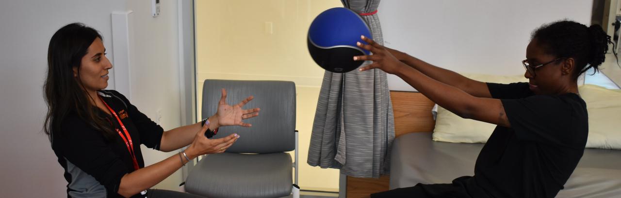 patient holds ball with hands during therapy with physical therapy