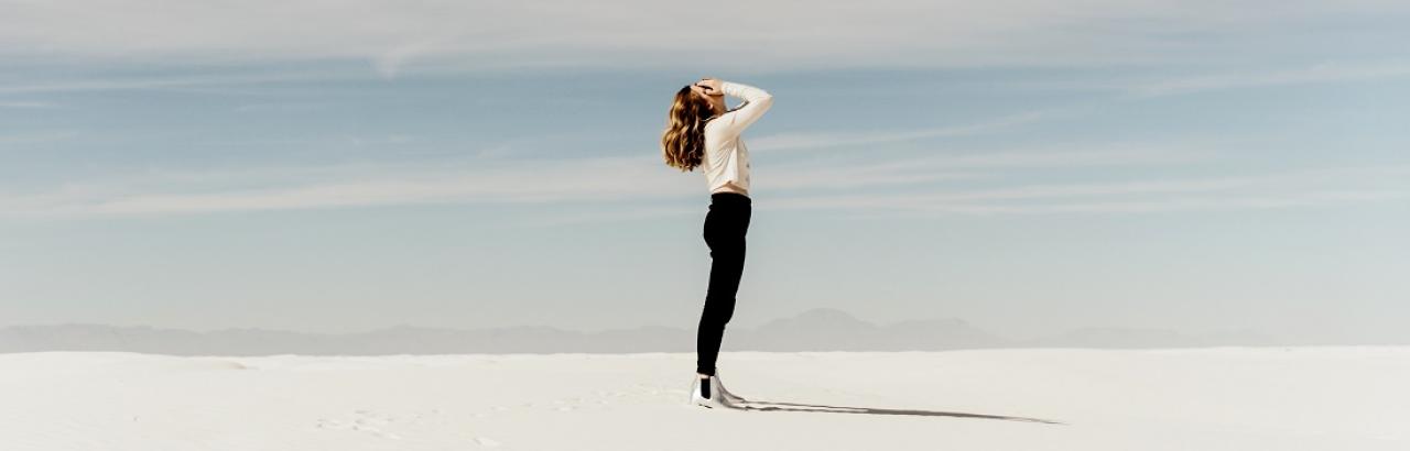 woman with face in hands in desert