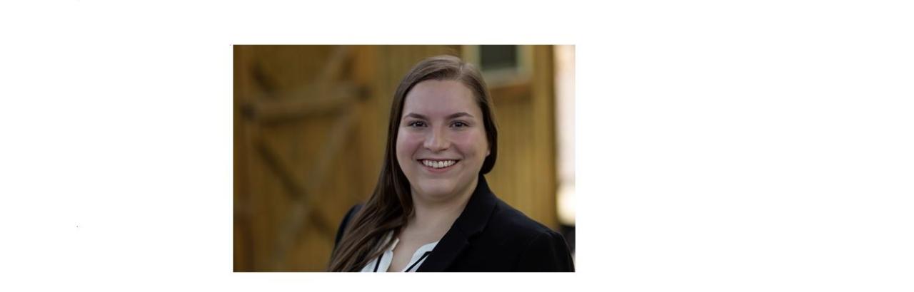 Head shot of Rachel Bond standing in front of a shed. 