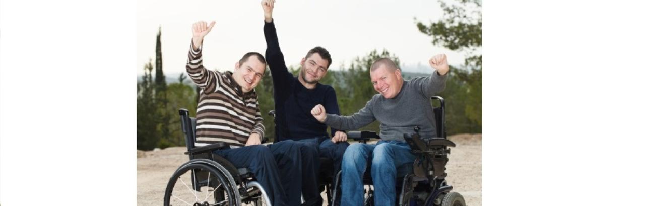 three happy men in wheelchairs