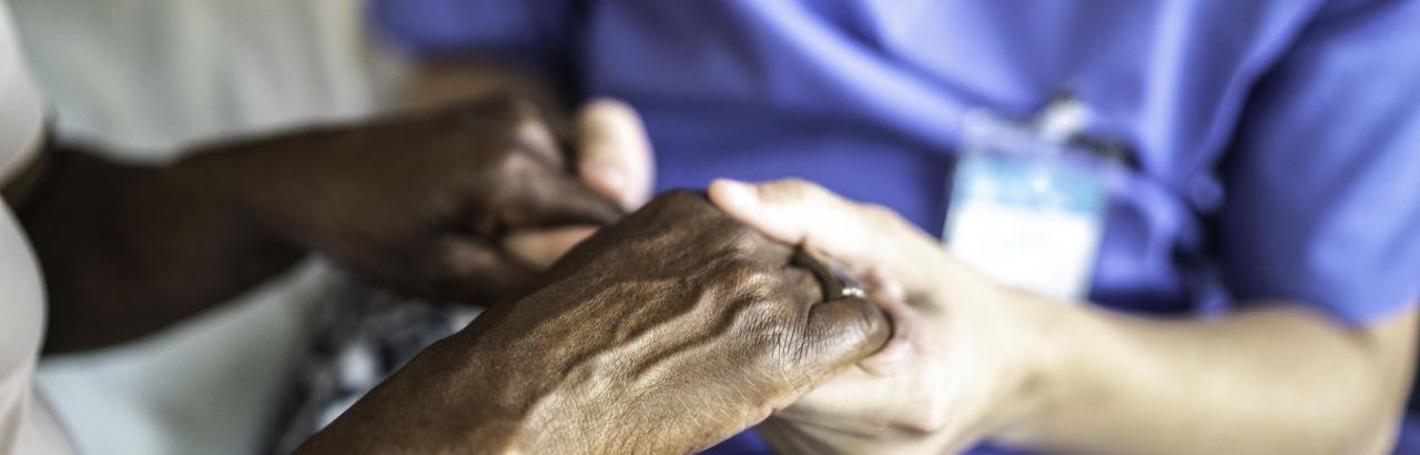 Nurse holds hands of patient