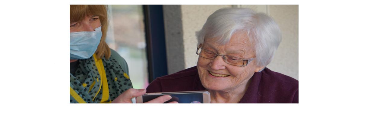 woman smiling and caretaker holding phone