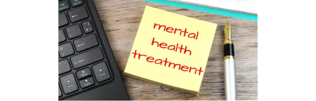 This image shows a corner of a black keyboard on the left hand side, a fountain pen on the right hand side, the head of a clipboard at the top, and in the center a post-it note that reads "Mental Health Treatment" in red ink.