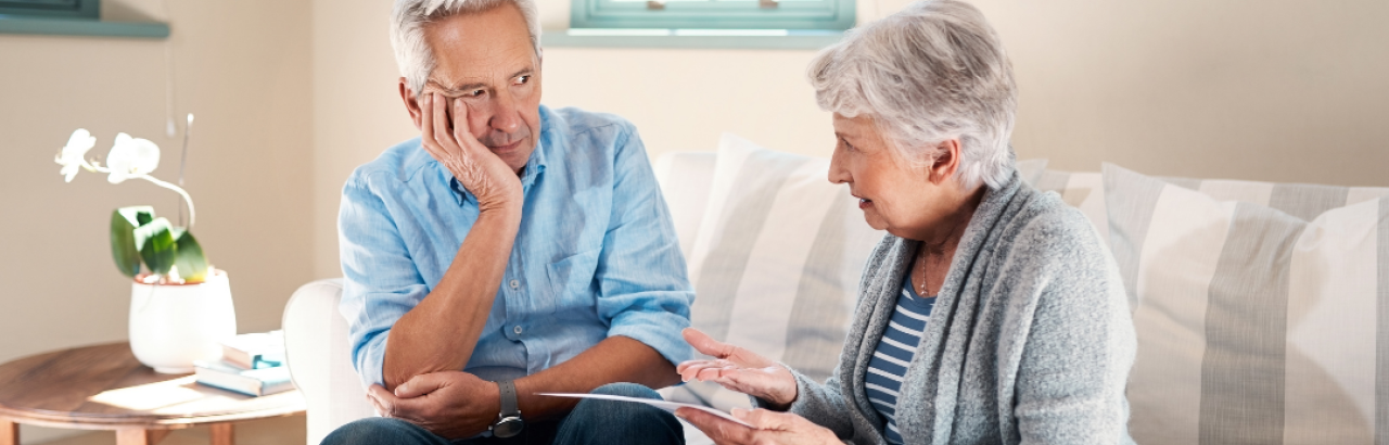 Older couple in their 70s looking at each other worried