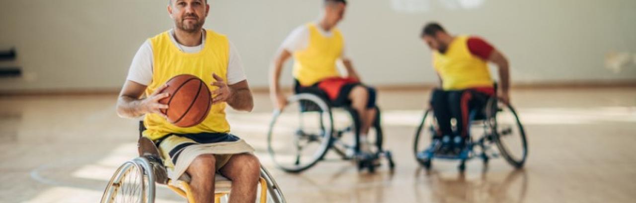Men playing basketball and using wheelchairs