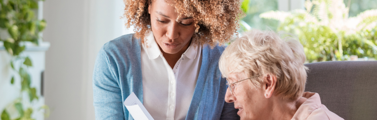 This is a picture of a black nurse and an elderly white woman working together to address the patients' care plan.