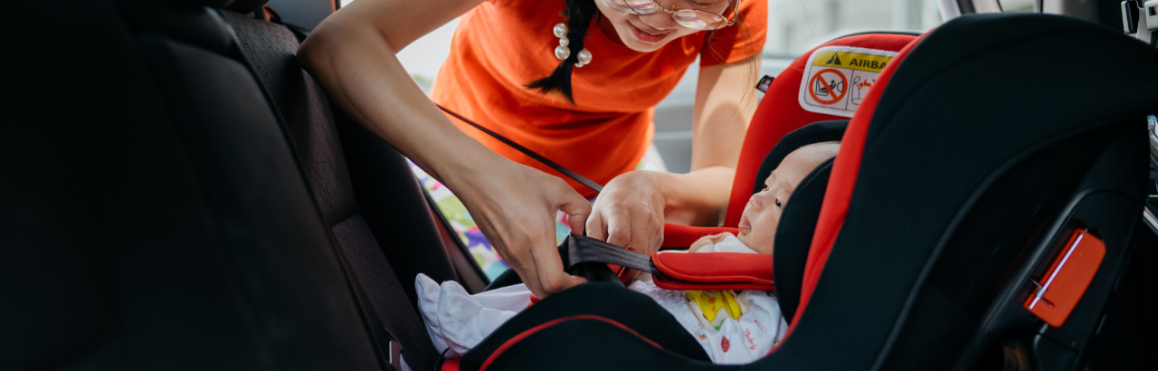 Mom buckling child into car seat