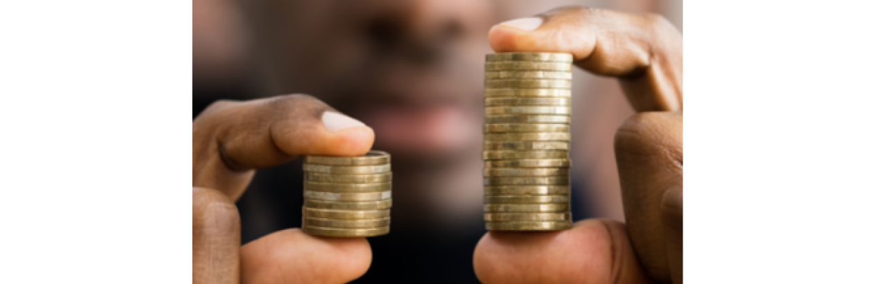 black man holding two stacks of coins in his hands